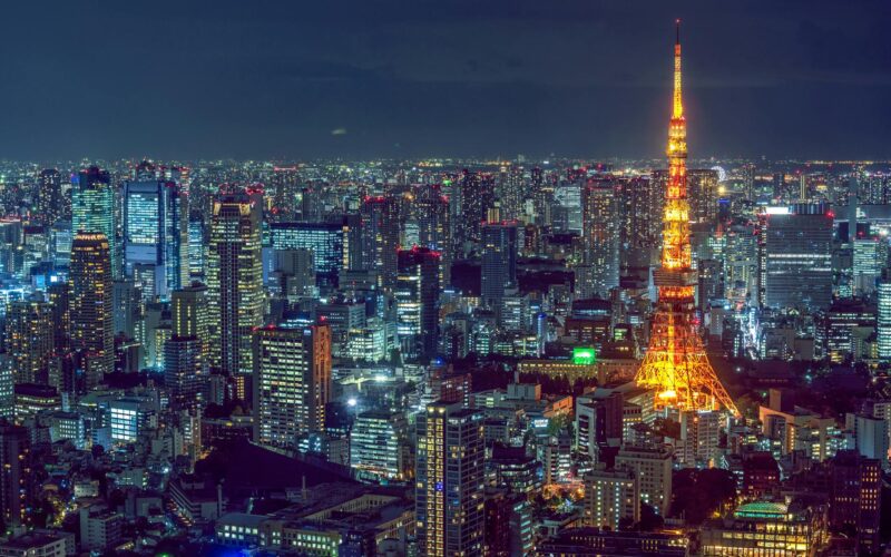 Stunning aerial view of Tokyo's vibrant cityscape with the illuminated Tokyo Tower at night.