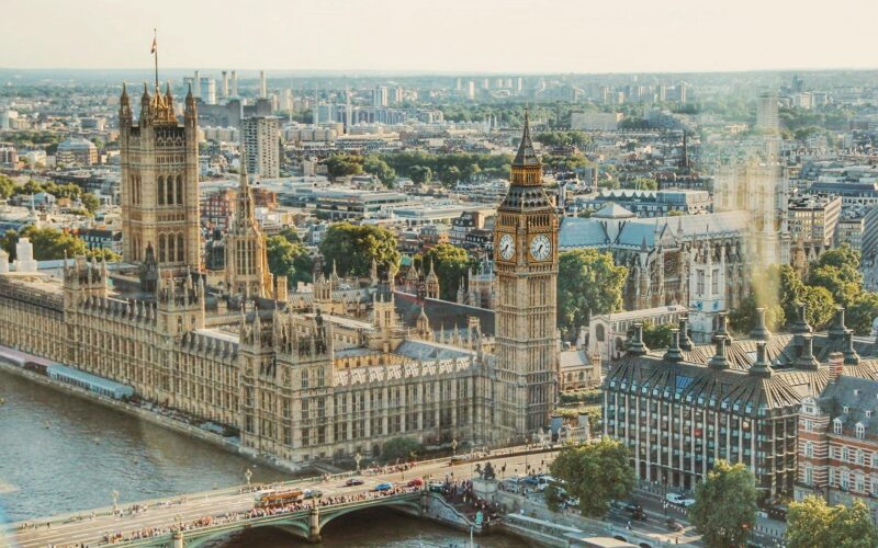 Stunning aerial view of London's iconic Big Ben and the river Thames under daylight.